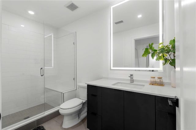 bathroom featuring visible vents, a stall shower, vanity, tile patterned floors, and toilet