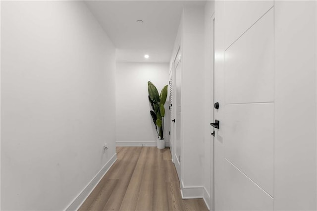 corridor featuring recessed lighting, baseboards, and wood finished floors