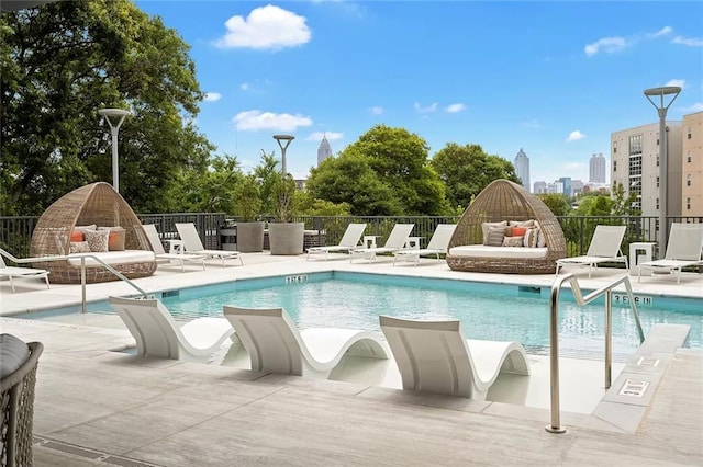 community pool featuring fence and a patio area