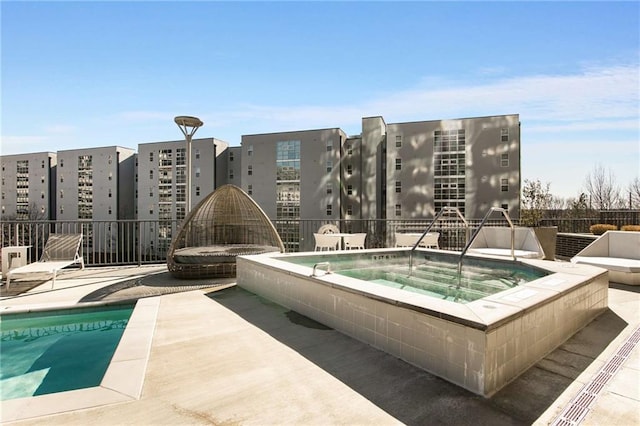 view of pool featuring a hot tub and a patio