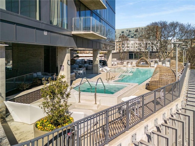 community pool featuring a hot tub and a patio area