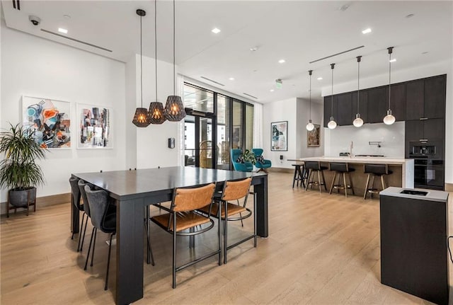 dining area with baseboards, recessed lighting, and light wood-style flooring