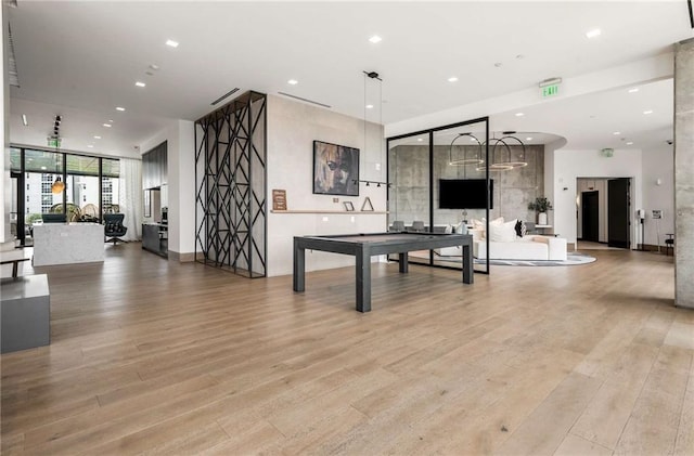 recreation room with recessed lighting, a wall of windows, and light wood-style flooring