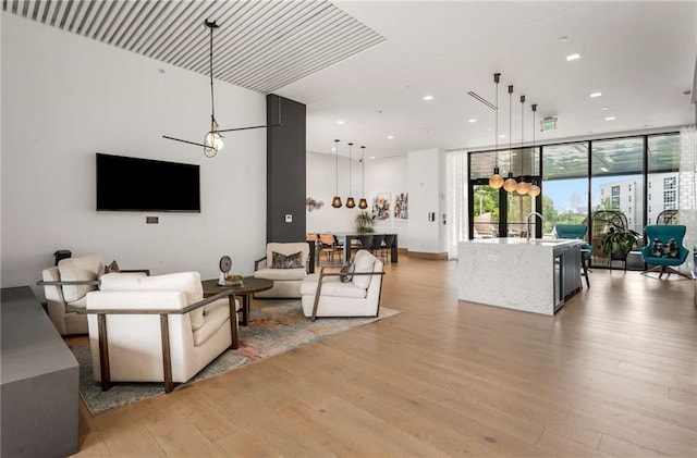 living room featuring recessed lighting, expansive windows, and light wood finished floors