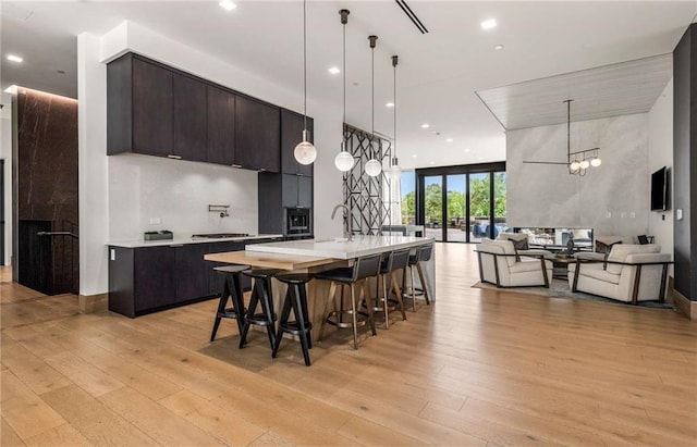 kitchen with light countertops, open floor plan, and light wood-style flooring