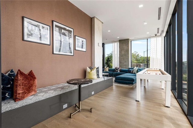 interior space featuring floor to ceiling windows, recessed lighting, and light wood-style flooring
