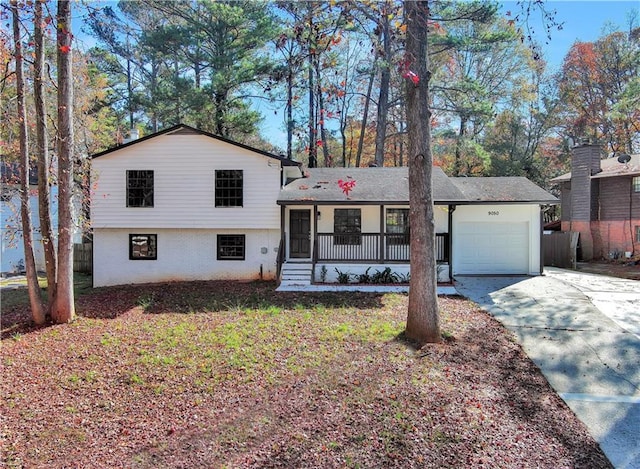 tri-level home featuring covered porch and a garage