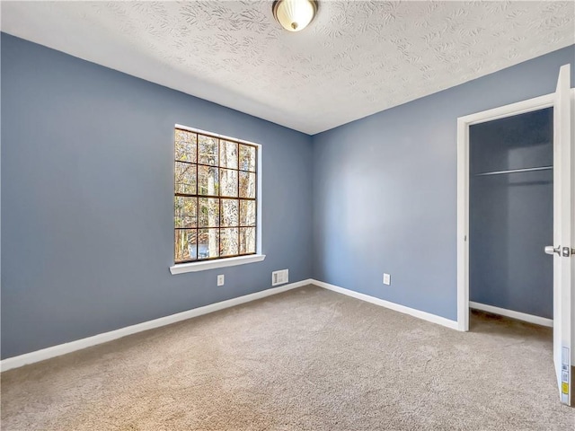 unfurnished bedroom with a textured ceiling, a closet, and carpet floors