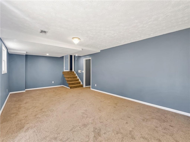 basement with a textured ceiling and carpet flooring