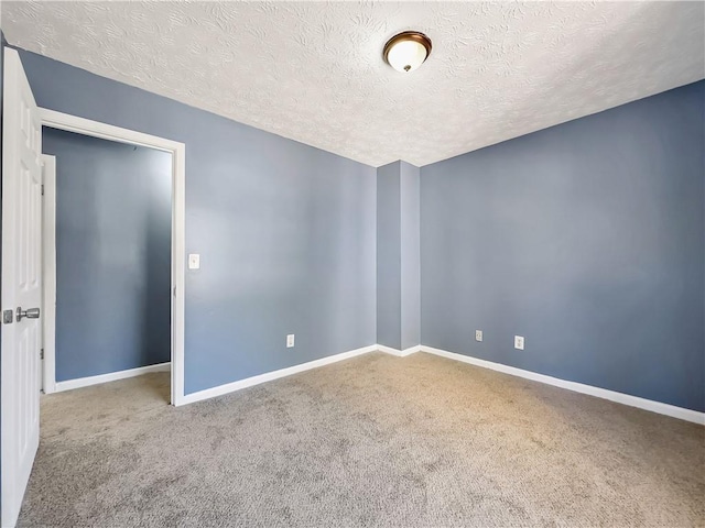 carpeted spare room featuring a textured ceiling