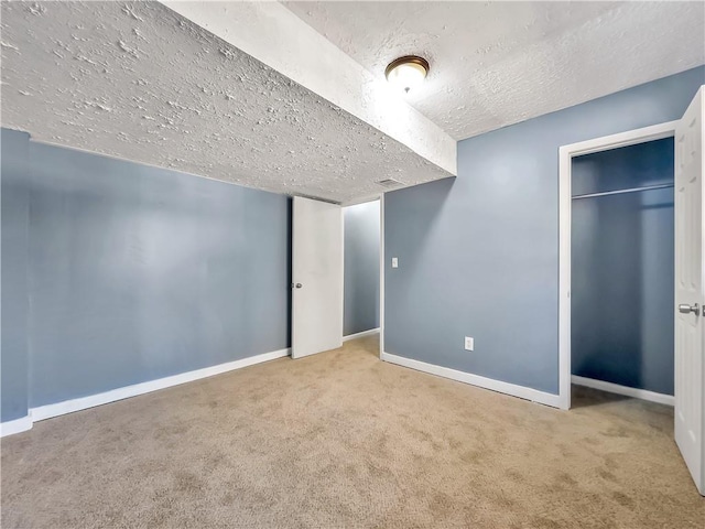 unfurnished bedroom featuring a textured ceiling, a closet, and carpet