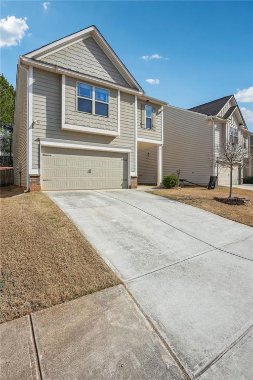 view of front of home with brick siding, driveway, and a garage