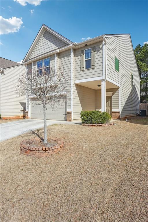 view of front of house with brick siding, a garage, and driveway