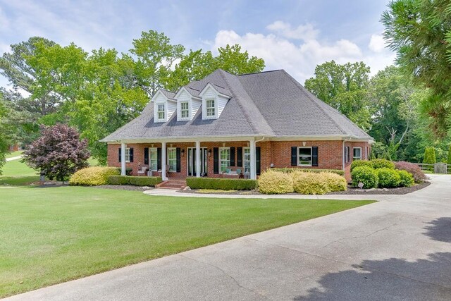 2623 Lindsey Grace Ln, Buford, GA 30519 - cape cod home with brick siding, a porch, and a front lawn