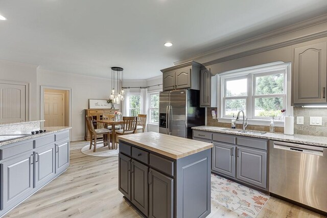 2623 Lindsey Grace Ln, Buford, GA 30519 - kitchen featuring stainless steel appliances, a sink, gray cabinetry, healthy amount of natural light, and crown molding
