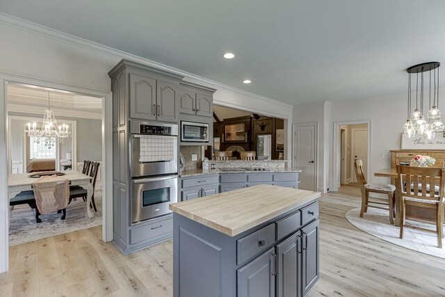 2623 Lindsey Grace Ln, Buford, GA 30519 - kitchen featuring gray cabinets, a chandelier, stainless steel appliances, crown molding, and light wood-type flooring