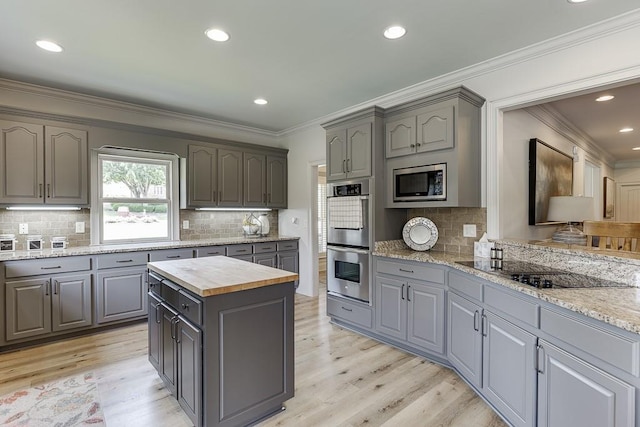 2623 Lindsey Grace Ln, Buford, GA 30519 - kitchen with gray cabinetry, appliances with stainless steel finishes, butcher block countertops, crown molding, and recessed lighting