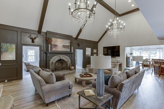 2623 Lindsey Grace Ln, Buford, GA 30519 - living room featuring high vaulted ceiling, a decorative wall, a chandelier, light wood-style floors, and beamed ceiling
