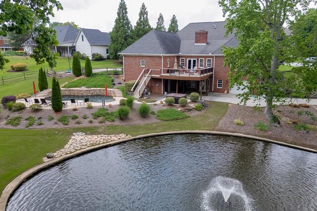 2623 Lindsey Grace Ln, Buford, GA 30519 - back of property with a deck with water view, brick siding, stairs, a patio area, and a chimney