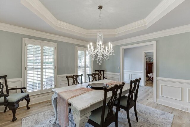 2623 Lindsey Grace Ln, Buford, GA 30519 - dining area with a tray ceiling, a chandelier, light wood-style flooring, a decorative wall, and wainscoting