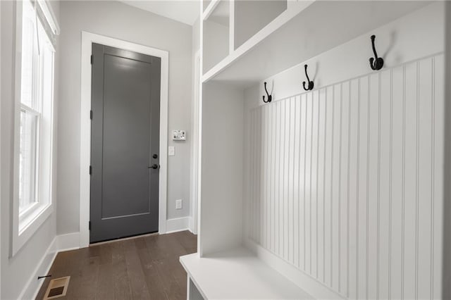 mudroom featuring baseboards, visible vents, and dark wood-type flooring