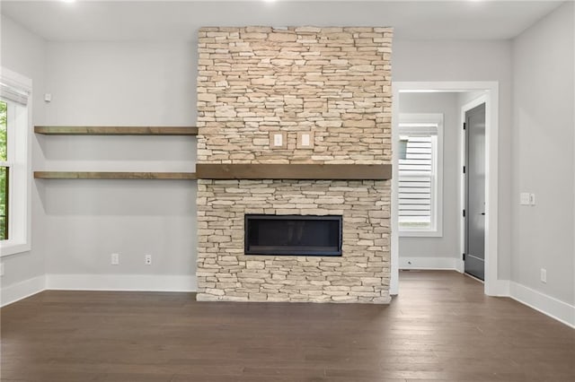 unfurnished living room featuring baseboards and wood finished floors