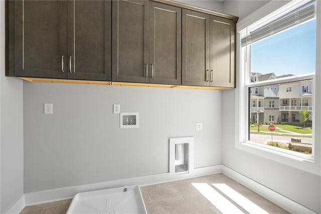 washroom with cabinet space, hookup for a washing machine, baseboards, and electric dryer hookup