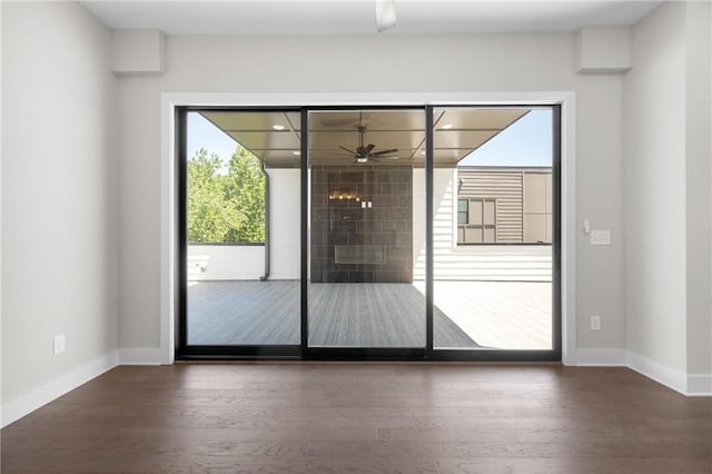 doorway featuring wood finished floors and baseboards