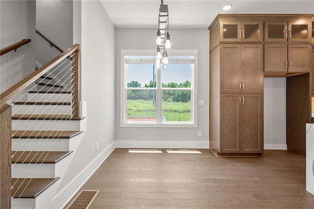 unfurnished dining area with visible vents, baseboards, wood finished floors, and recessed lighting