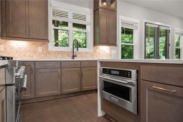 kitchen featuring appliances with stainless steel finishes, backsplash, and a healthy amount of sunlight