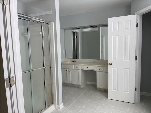 bathroom with a stall shower, tile patterned floors, vanity, and baseboards