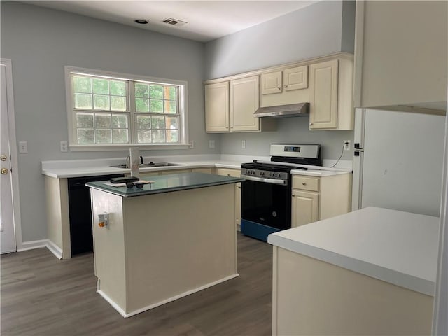 kitchen featuring stainless steel gas stove, wall chimney range hood, dark wood-style floors, a sink, and a kitchen island