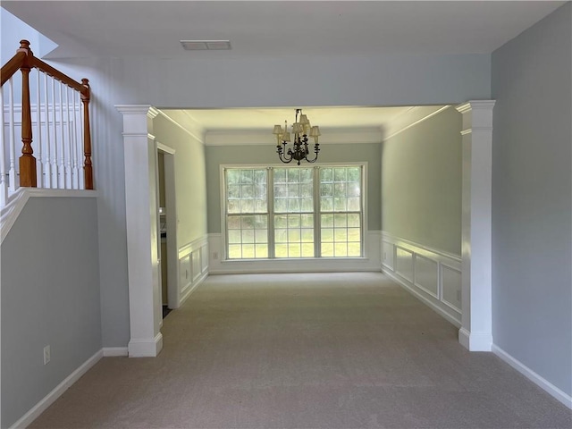 unfurnished dining area with carpet floors, a chandelier, wainscoting, and ornamental molding