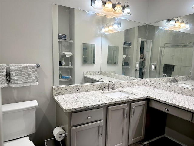 full bath with a stall shower, toilet, and vanity