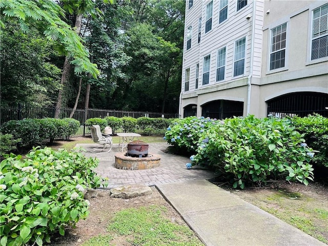 view of yard featuring a fire pit, fence, and a patio