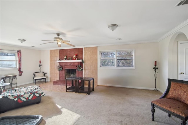 living area featuring carpet, visible vents, ornamental molding, a brick fireplace, and baseboards