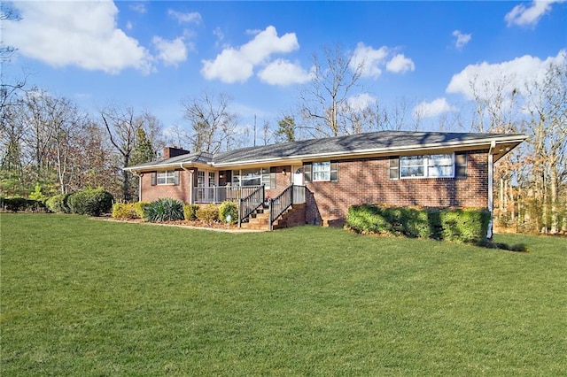 rear view of house with a yard, brick siding, and a porch