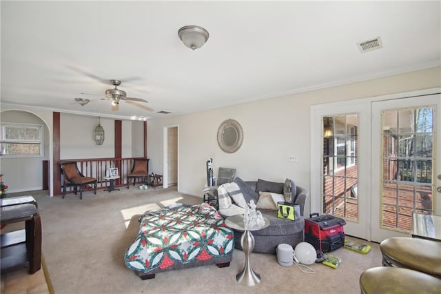 living area featuring a ceiling fan, carpet, a healthy amount of sunlight, and visible vents