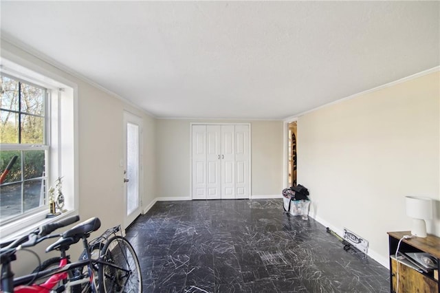 exercise area with marble finish floor, ornamental molding, and baseboards