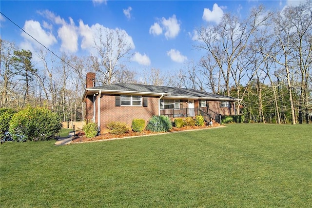 view of front of home with brick siding, a chimney, and a front lawn