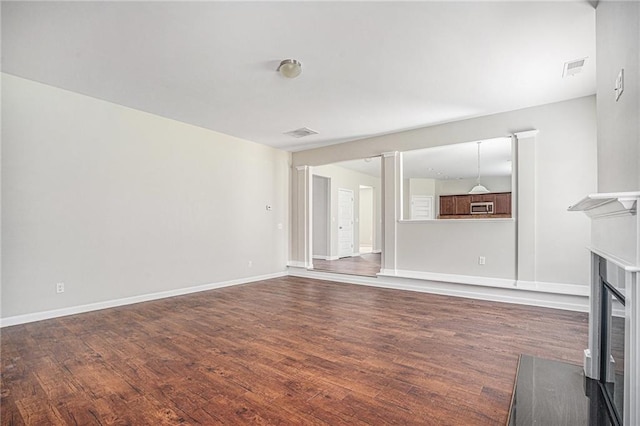 unfurnished living room with dark wood-type flooring