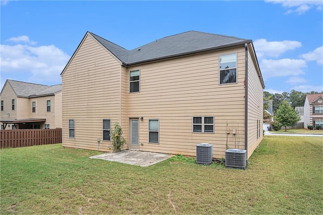 rear view of house with central AC, a patio area, and a yard