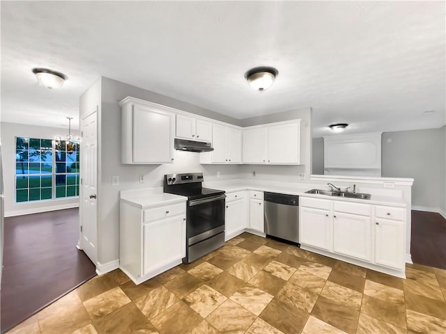 kitchen featuring stainless steel appliances, white cabinets, an inviting chandelier, and sink