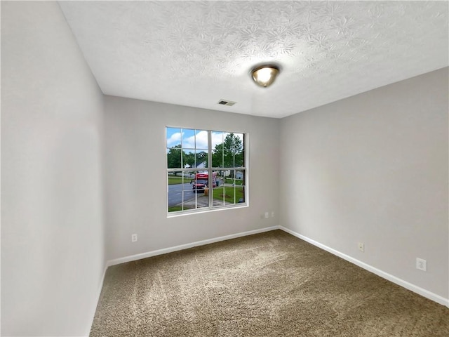 carpeted empty room with a textured ceiling