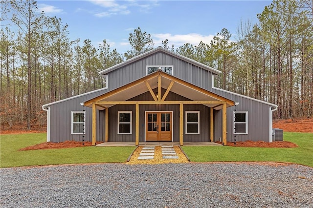 view of front facade featuring french doors, central AC, and a front lawn