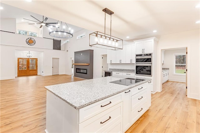 kitchen with pendant lighting, white cabinetry, a center island, stainless steel double oven, and black electric cooktop