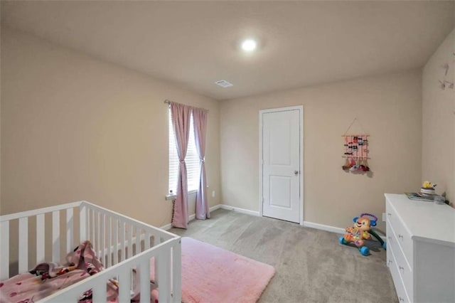 bedroom with light carpet and a nursery area