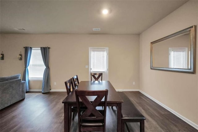 dining area with a healthy amount of sunlight and dark hardwood / wood-style floors