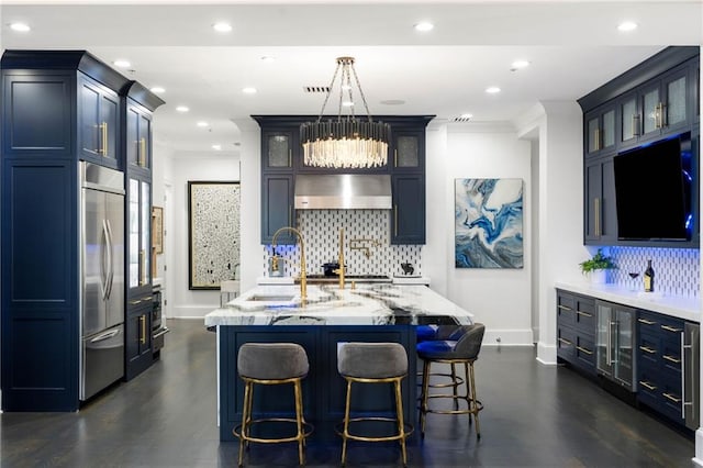 3286 Northside Pkwy NW Unit Ph2, Atlanta, GA 30327 - kitchen featuring range hood, built in refrigerator, light stone counters, an island with sink, and backsplash