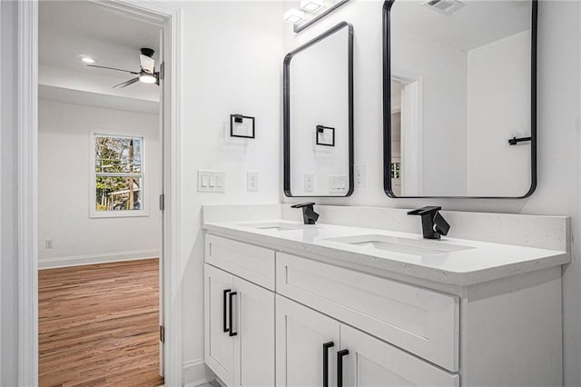 bathroom with wood-type flooring, ceiling fan, and vanity